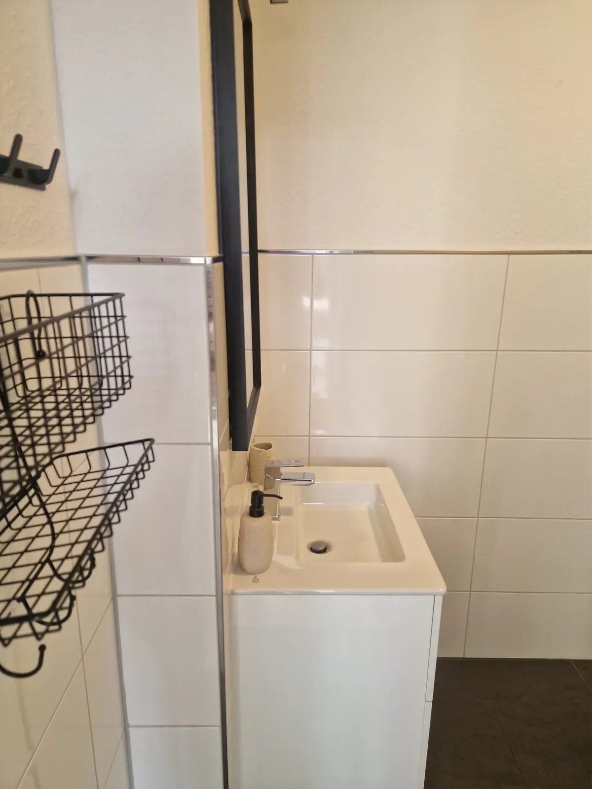 Waschbecken mit Armatur, Spiegel und gefliester Wand
