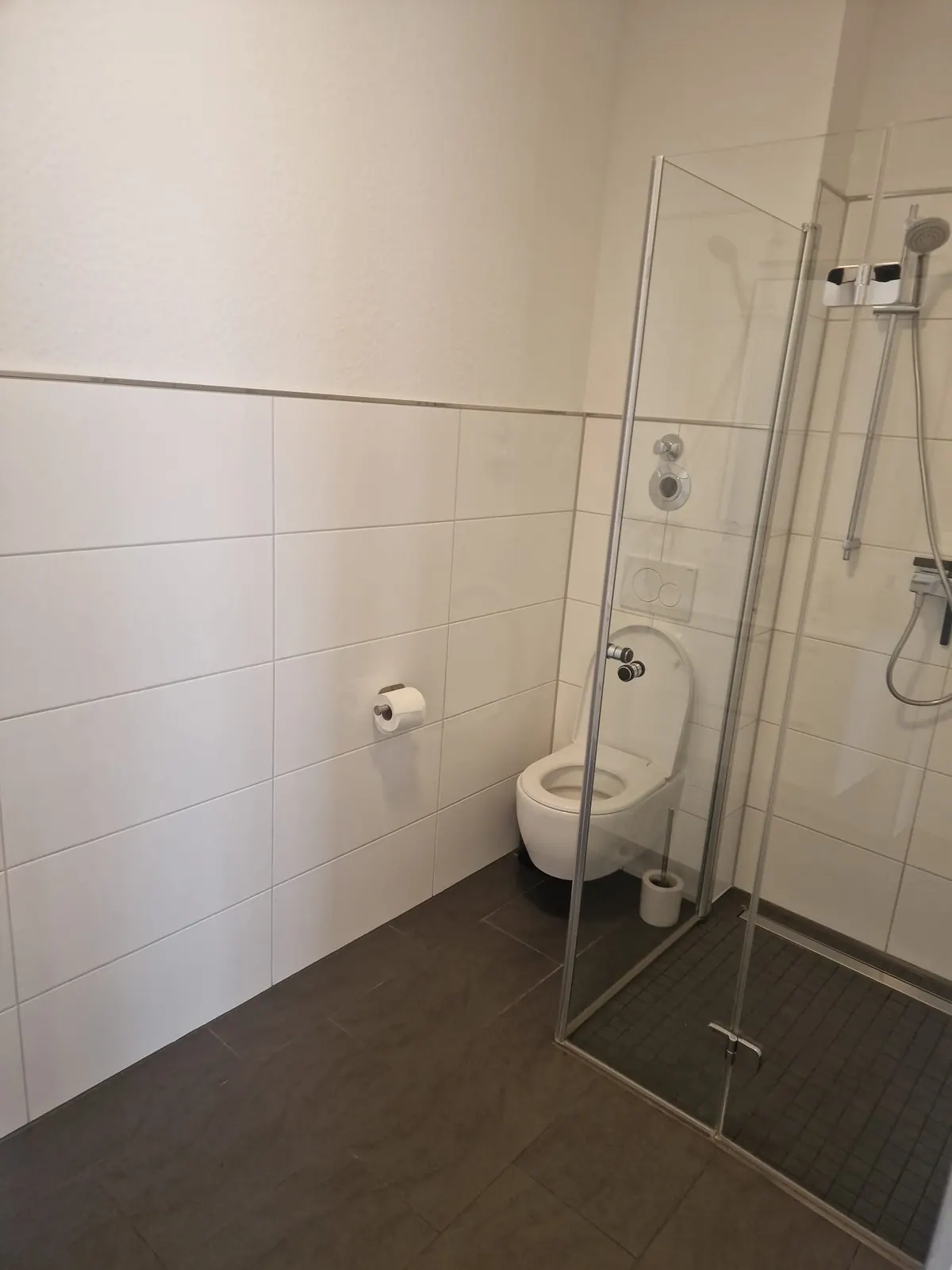Gefliestes Bad mit Dusche und Toilette