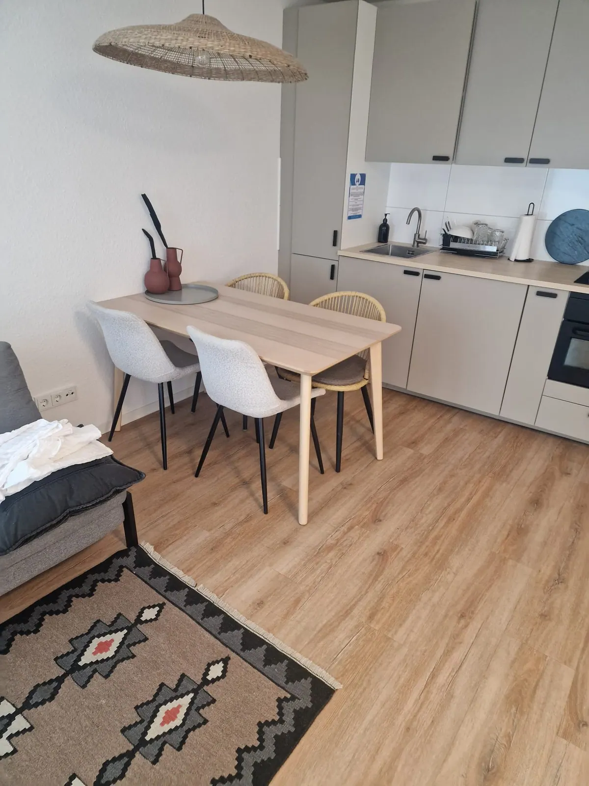 Esstisch und Küchenzeile in einem möblierten Apartment